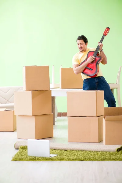 Joven hombre guapo mudándose a casa nueva con cajas —  Fotos de Stock