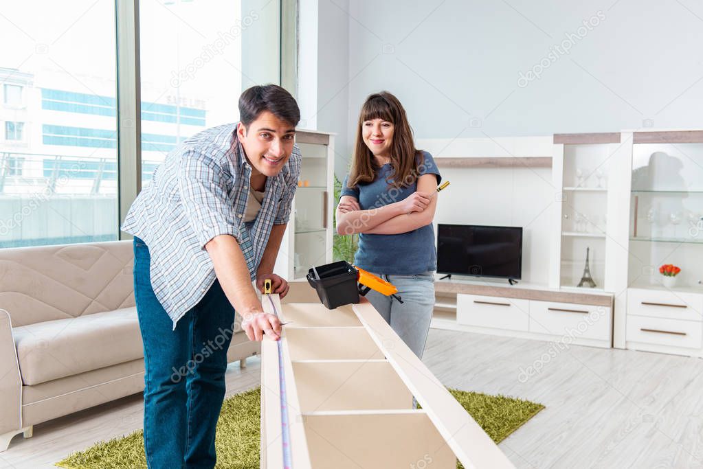 Young family assembling furniture at new house