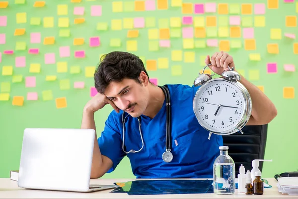Ung läkare med många påminnelser och brådskande arbete — Stockfoto