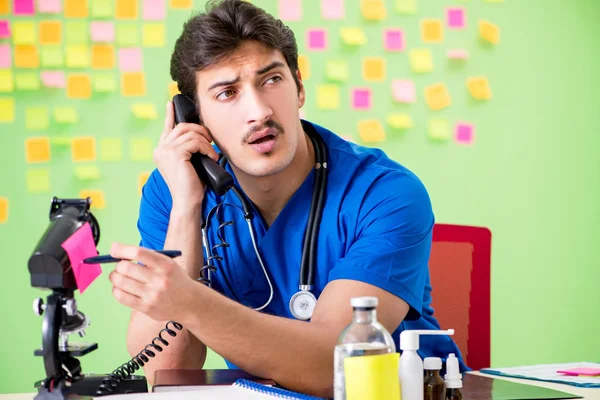 Giovane medico con molti promemoria e lavoro urgente — Foto Stock