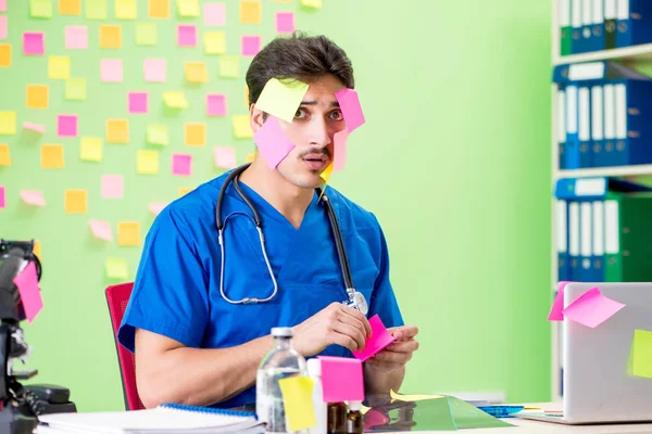 Young doctor with many reminders and urgent work — Stock Photo, Image