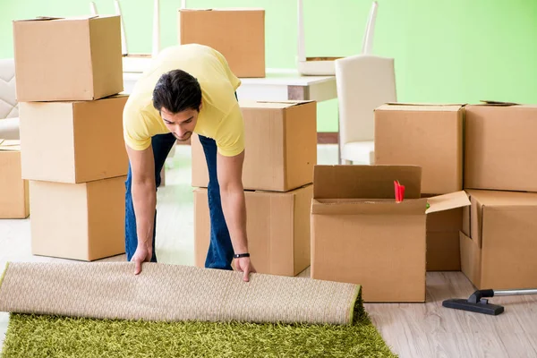 Young handsome man moving in to new house with boxes — Stock Photo, Image