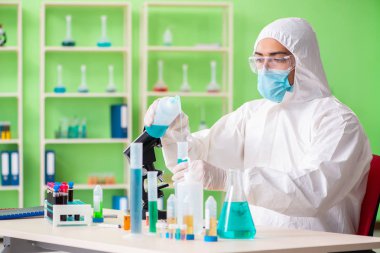 Laboratuvarda yeni bir deney üzerinde çalışan kimyager.