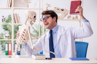 Çılgın profesör insan iskeleti üzerinde çalışıyor.