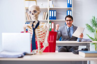 İskeletle çalışan bir iş adamı.