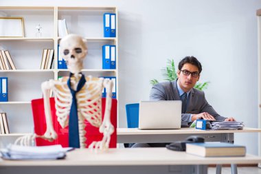 İskeletle çalışan bir iş adamı.