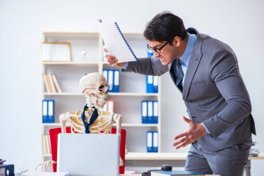 Kızgın patron iskelet çalışanına bağırıyor.