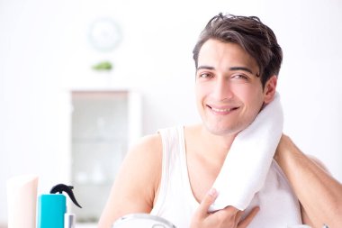 Genç yakışıklı adam aynaya bakıyor. 
