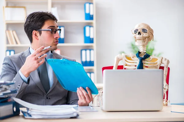 Businessman working with skeleton in office — Stock Photo, Image