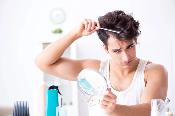 Jovem homem bonito olhando no espelho — Fotografia de Stock