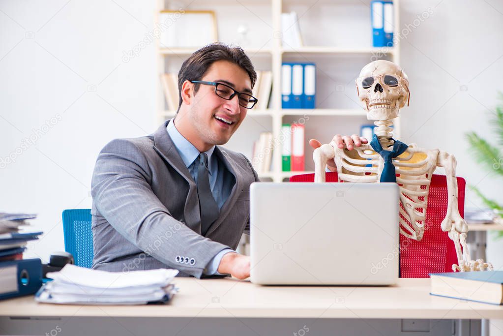 Businessman working with skeleton in office