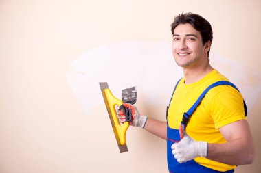 Duvara alçı yapıştıran genç müteahhit.