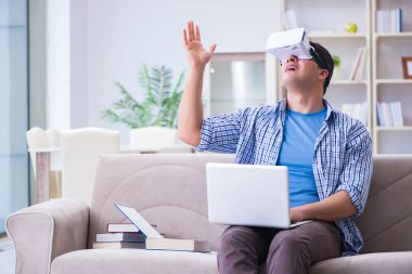 Evde sanal gerçeklik gözlükleriyle serbest çalışan bir öğrenci.