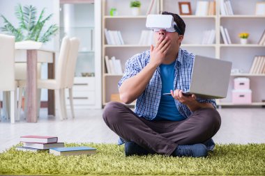 Evde sanal gerçeklik gözlükleriyle serbest çalışan bir öğrenci.