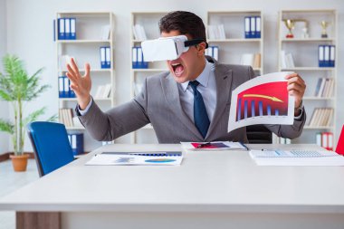 Ofiste sanal gerçeklik gözlüklü bir iş adamı var.