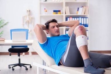 Spor sakatlığı geçiren hasta doktoru ziyaret ediyor.