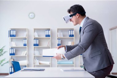 Ofiste sanal gerçeklik gözlüklü bir iş adamı var.