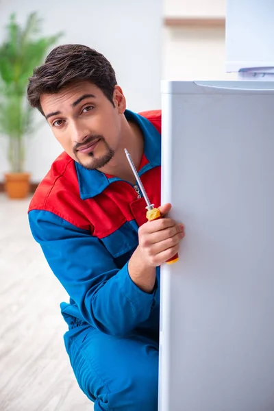 Professional contractor repairing broken fridge