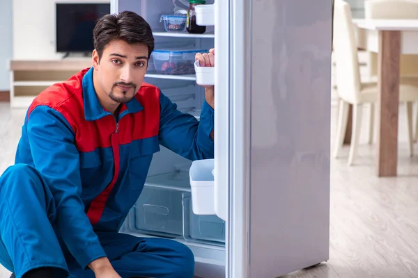 Professional contractor repairing broken fridge