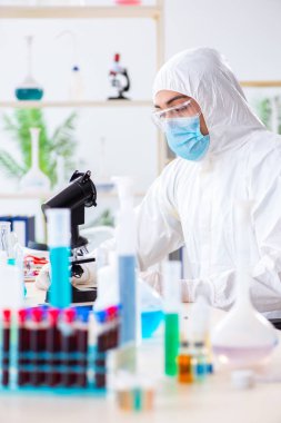 Laboratuvarda kimyasallar üzerinde çalışan genç bir kimyager.
