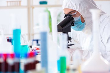 Laboratuvarda kimyasallar üzerinde çalışan genç bir kimyager.