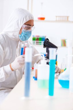 Laboratuvarda kimyasallar üzerinde çalışan genç bir kimyager.