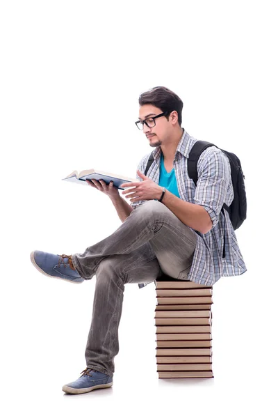 Jonge studente zit op de top van boek stapel op wit — Stockfoto