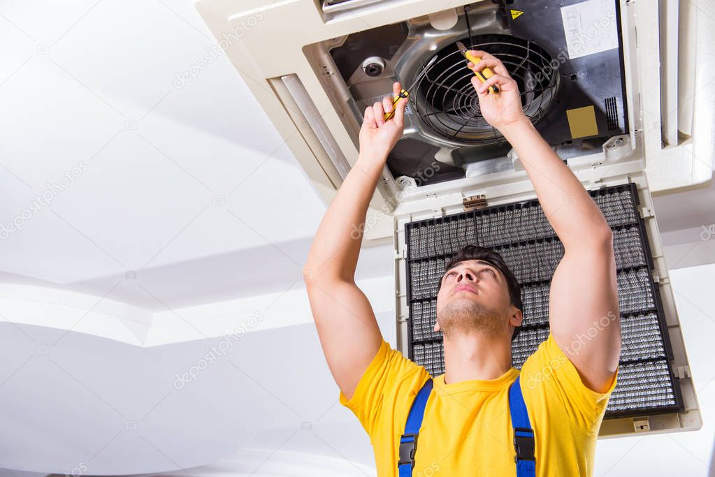 Repairman repairing ceiling air conditioning unit