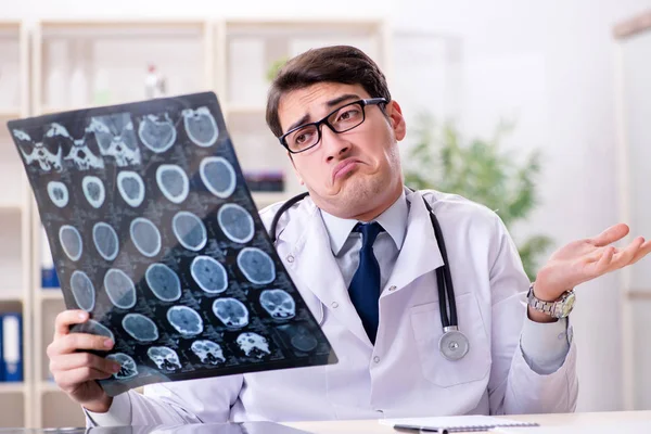 Młody lekarz oglądający zdjęcia rentgenowskie w klinice — Zdjęcie stockowe
