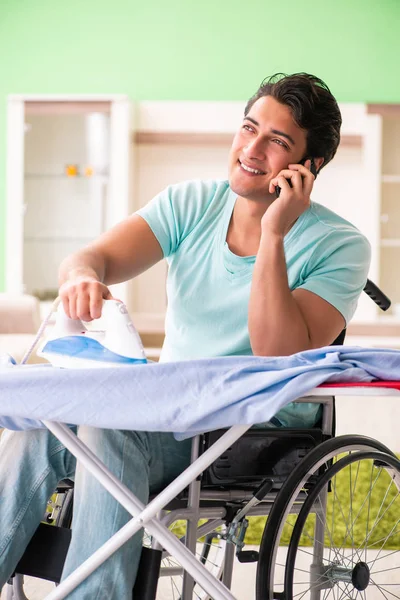 Инвалид на инвалидной коляске гладильная одежда — стоковое фото