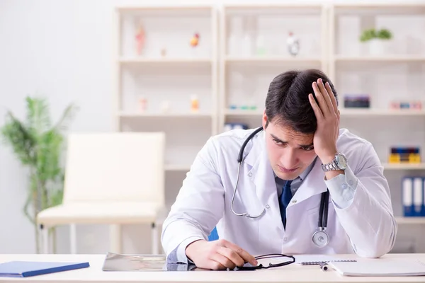 Jovem médico sentado no escritório — Fotografia de Stock