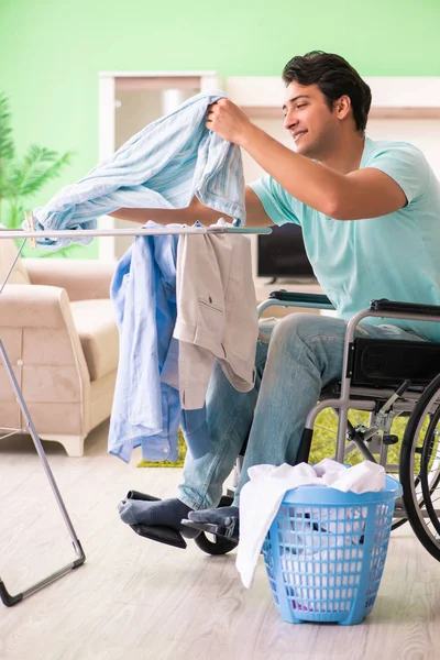 Tekerlekli sandalyedeki engelli adam çamaşır yıkıyor — Stok fotoğraf