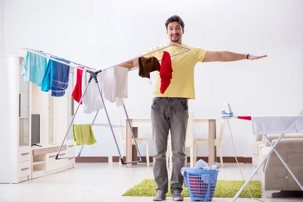 Przystojny mąż robi pranie w domu. — Zdjęcie stockowe