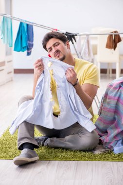 Yakışıklı koca evde çamaşır yıkıyor.