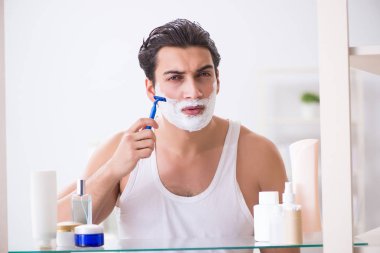 Genç yakışıklı adam sabah erkenden tıraş oluyor.