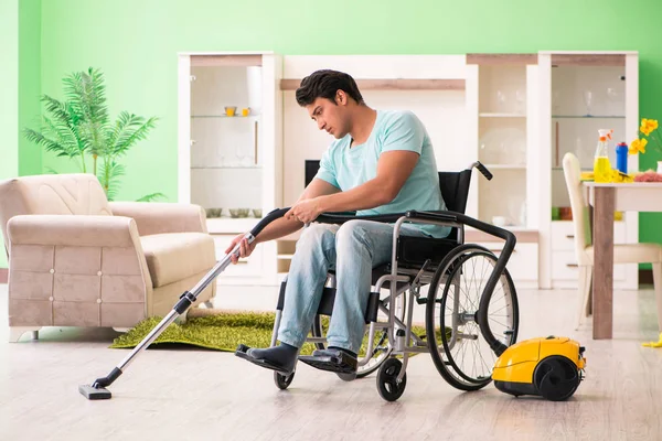 Homme handicapé en fauteuil roulant maison d'aspirateur — Photo