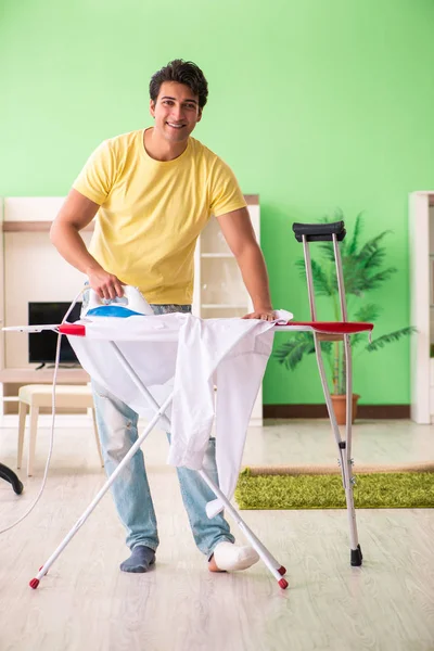 Poot gewonde man doet kleding strijken thuis — Stockfoto