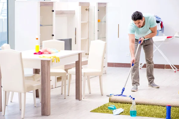 若いです魅力的な男夫ありますmoppingで家 — ストック写真