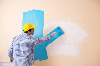 Evdeki duvarı boyayan ressam.