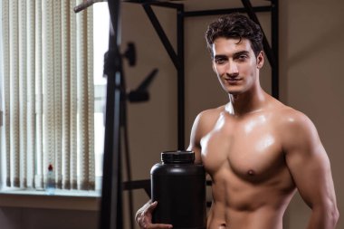 Spor salonunda besin takviyesi olan bir adam.