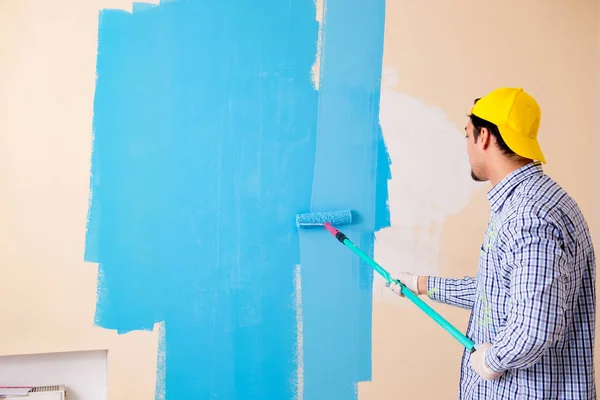 Pintor hombre pintando la pared en casa —  Fotos de Stock