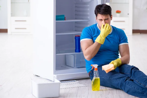 Чоловік чистить холодильник в концепції гігієни — стокове фото