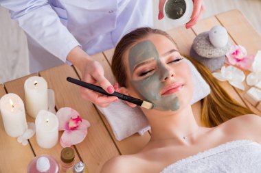 Yüz maskeli, spa sağlık konsepti olan genç bir kadın.