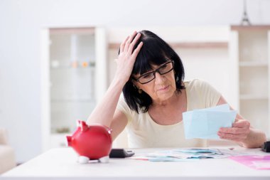 Faturalarını ödemeye çalışan olgun bir kadın.