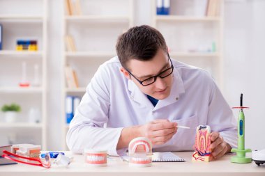 Tıp laboratuarına diş implantı yerleştiren dişçi.