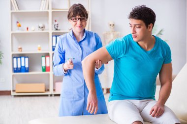 Doktor çekiçle sinir reflekslerini kontrol ediyor