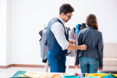 Profesyonel terzi resmi kıyafet için ölçü alıyor.