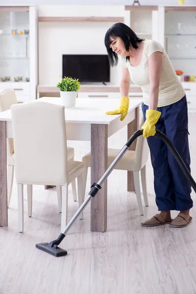 Senior old woman tired after vacuum cleaning house