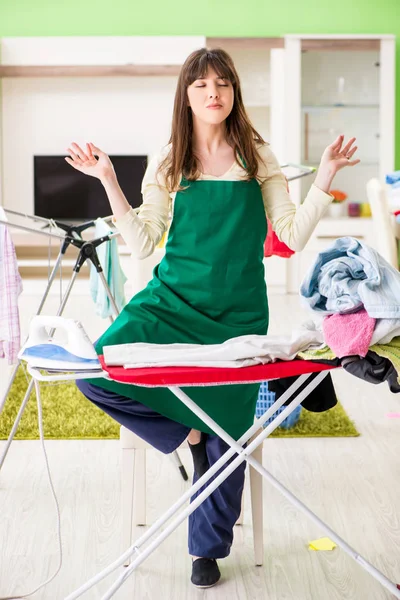 Mujer joven planchando ropa en casa — Foto de Stock