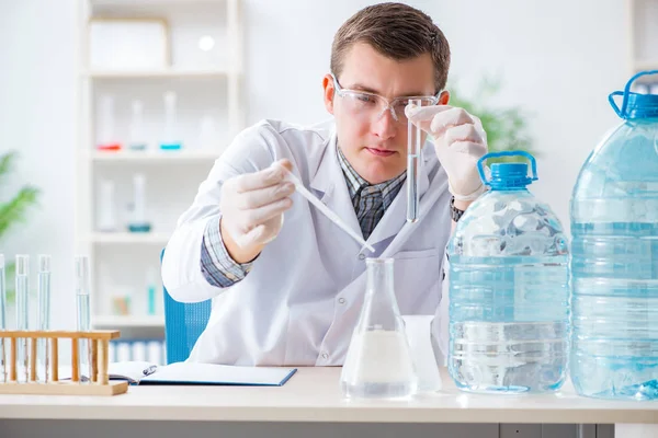 Joven estudiante de química experimentando en laboratorio — Foto de Stock